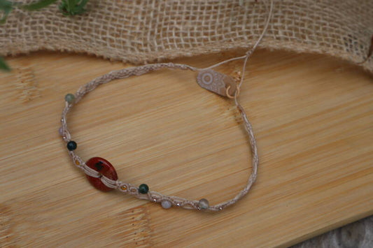Detail van rode jaspis donut in macramé ketting
