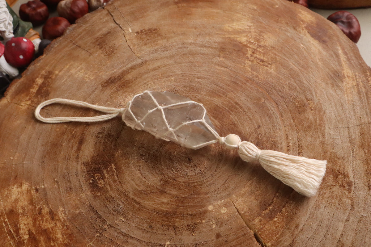 Macramé raamhanger met bergkristalpunt in een naturel wit koord van katoen vanaf de zijkant gezien